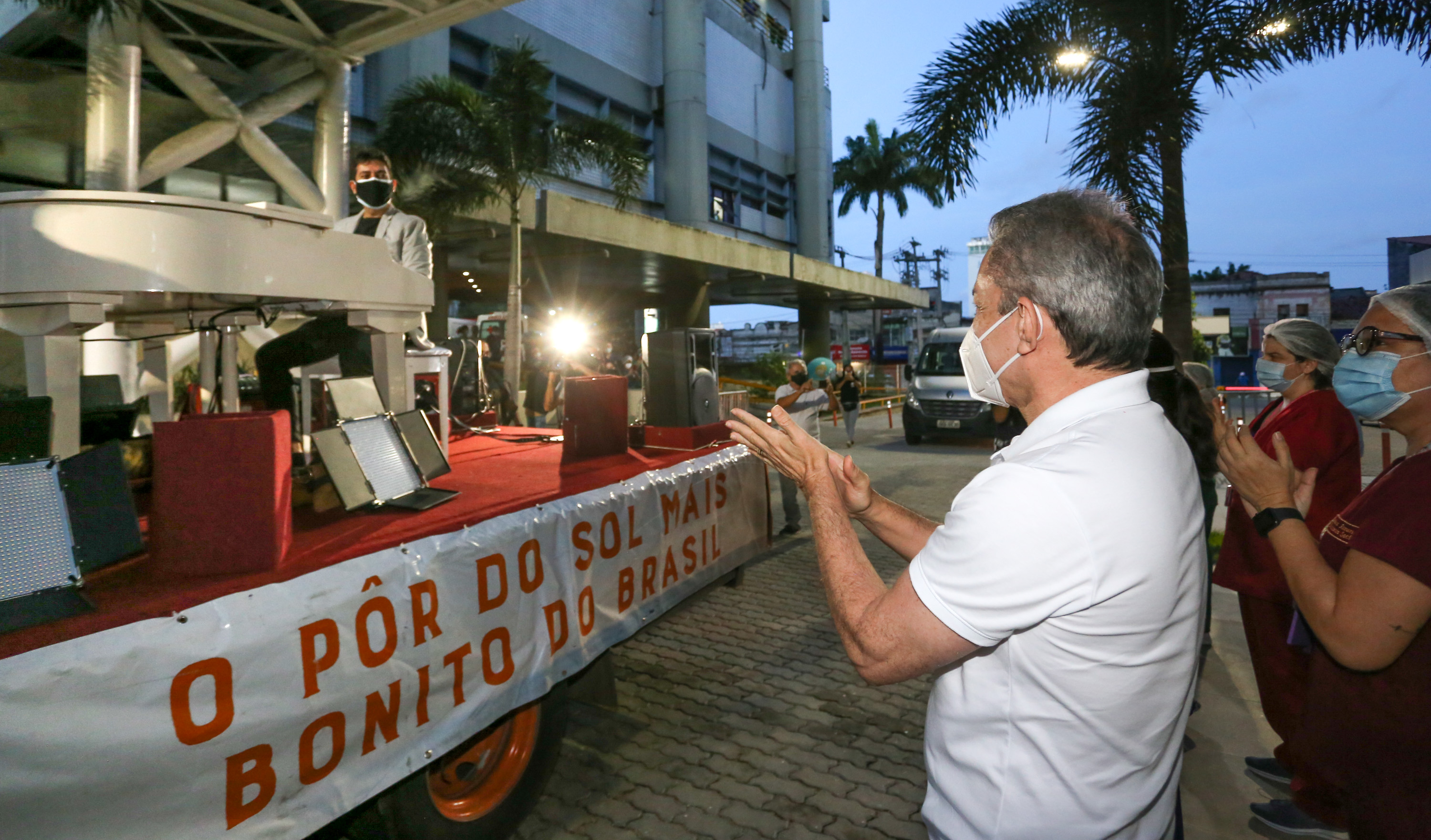 prefeito sarto aplaude o pianista felipe adjafre na frente do IJF. O pianista está em cima de um caminhão